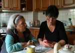 Aide à domicile accompagnant une personne âgée chez elle