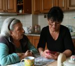 Aide à domicile accompagnant une personne âgée chez elle